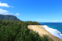 Panoramic view of Hanalei Bay’s calm waters and sandy beach.